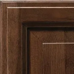 Close-up of a dark brown wooden cabinet door showing detailed paneling and grain.