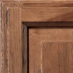 Wooden cabinet detail with a brown, textured finish.
