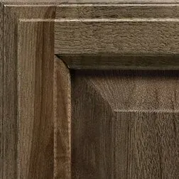 Close-up of a wooden cabinet door showing wood grain and molding details.