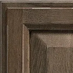 Close-up of a wood cabinet door with a dark brown, textured finish, showcasing the grain details.