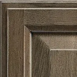 Close-up of a wood cabinet door with a square panel and a brown finish.
