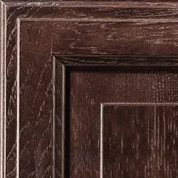 Close-up of a stained, dark brown wooden cabinet door, showing the grain and panel details.