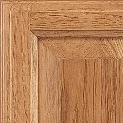 Close-up of a wood cabinet door, showing the grain and detailed trim.