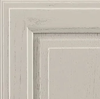 Close-up of a distressed off-white cabinet door with raised panel design.