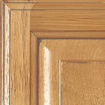 Close-up of a light brown wooden cabinet door with recessed panel and decorative edge.
