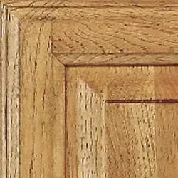 Close-up of wooden cabinet corner, showing grain and recessed panel.