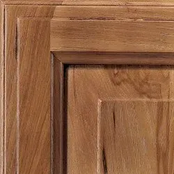 Wooden cabinet door detail with raised panel and decorative trim.