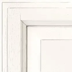 White cabinet corner showing layered trim and panel.