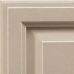 Close-up of a corner of a light-colored, framed cabinet door.