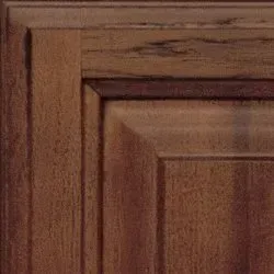 Close-up of a wooden cabinet corner, showing a medium brown stain with visible wood grain.