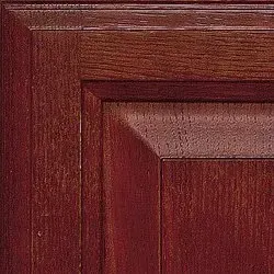Close-up of a dark-stained wooden cabinet door, showing the grain and trim details.