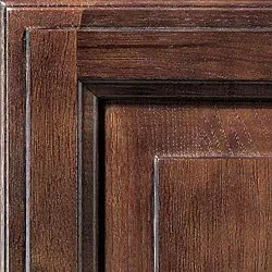 Close-up of dark wood cabinet door, with visible grain and framed panel.