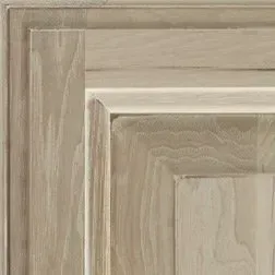 Close-up of a wooden cabinet door, showing detailed wood grain and a light brown color.