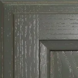 Close-up of a gray cabinet door with wood grain texture.