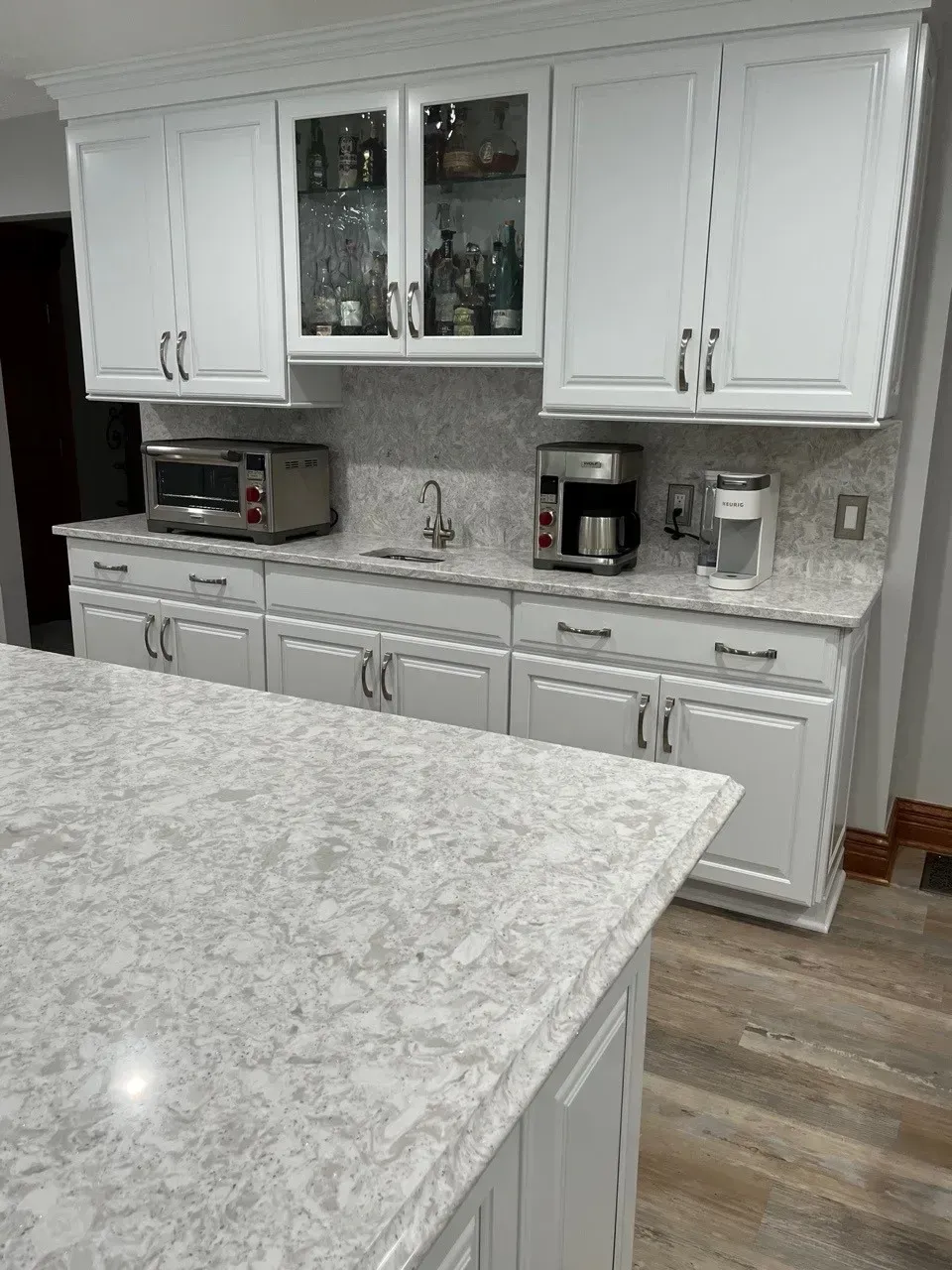 White kitchen with a countertop, cabinets, and appliances.