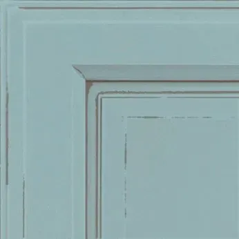 Corner of a light blue cabinet with distressed edges.