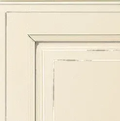 Cream-colored kitchen cabinet door with recessed panel and decorative molding.