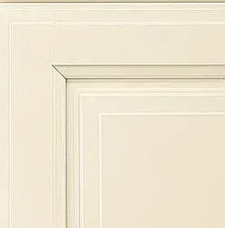 Close-up of an off-white cabinet door with recessed panel and detailed trim.
