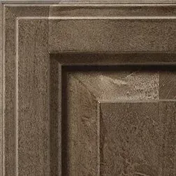 Corner of a dark brown textured cabinet door with a layered, framed design.