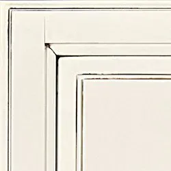 Off-white cabinet door corner with inset panel and subtle distressed edges.
