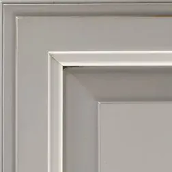 Close-up of a white cabinet corner with layered molding.