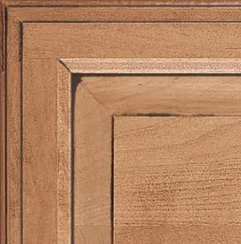 Corner detail of a wooden cabinet door, with recessed panel and raised trim.