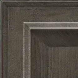 Close-up of dark gray, rustic wood cabinet door detail with raised panel.
