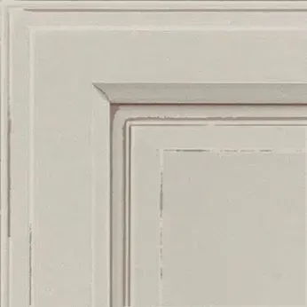 Corner of a white cabinet door with raised panel and decorative molding.