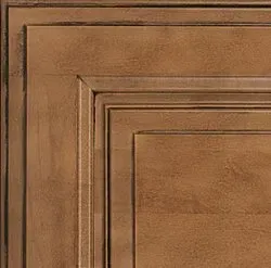 Corner of a brown, raised panel cabinet door with layered trim.