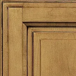 Close-up of a golden-brown cabinet door showing layered panel and recessed details.