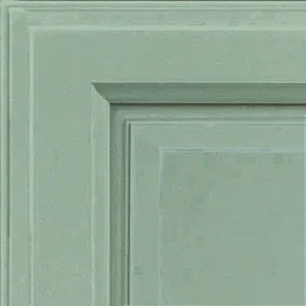 Corner detail of a light green cabinet door with recessed panel and molded trim.