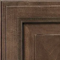 Close-up of a dark brown, layered wooden cabinet door with square panel.