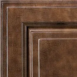 Close-up of a dark, textured, wooden cabinet door with layered rectangular panels.