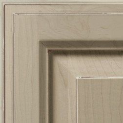 Close-up of a light beige kitchen cabinet door with layered paneling.