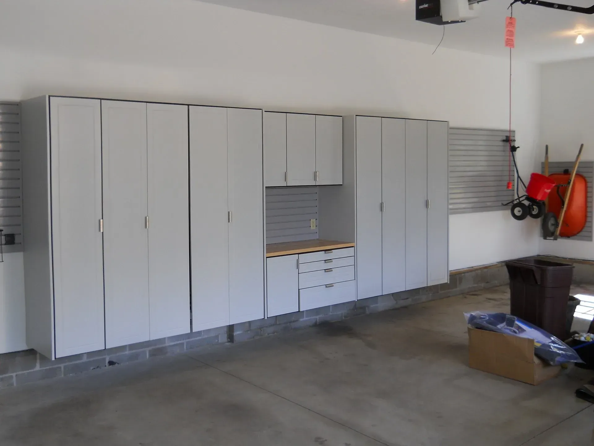 Garage with gray cabinets and a workbench along one wall.