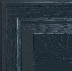 Close-up of a dark blue wooden cabinet door, showcasing wood grain and panel details.