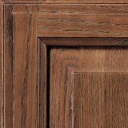 Close-up of a brown wooden cabinet door, showing detailed grain and corner molding.