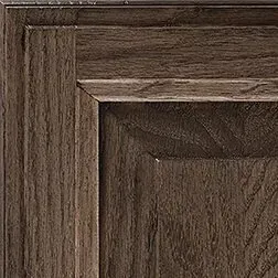 Close-up of a dark brown wooden cabinet door showing the grain and panel design.