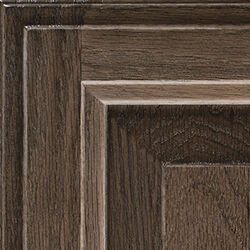 Close-up of a dark brown wood cabinet door with layered panels and visible wood grain.