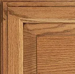 Close-up of wooden cabinet door corner with visible grain in a warm brown tone.