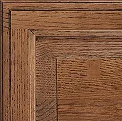 Close-up of a wood cabinet corner, showing detailed grain in various shades of brown.