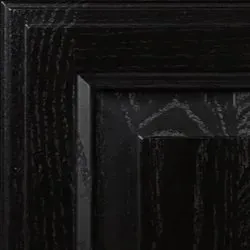 Close-up of a dark, black stained wood cabinet door with visible wood grain.