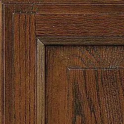 Close-up of a dark stained wood cabinet door corner, showing grain and layered molding.