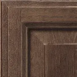 Close-up of a dark wood cabinet door corner with panel and recessed detail.