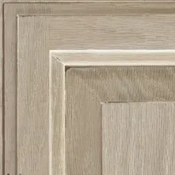 Close-up of a weathered, light-toned wooden cabinet panel with recessed square details.