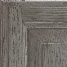 Gray wooden cabinet door, showing wood grain detail and recessed panel.