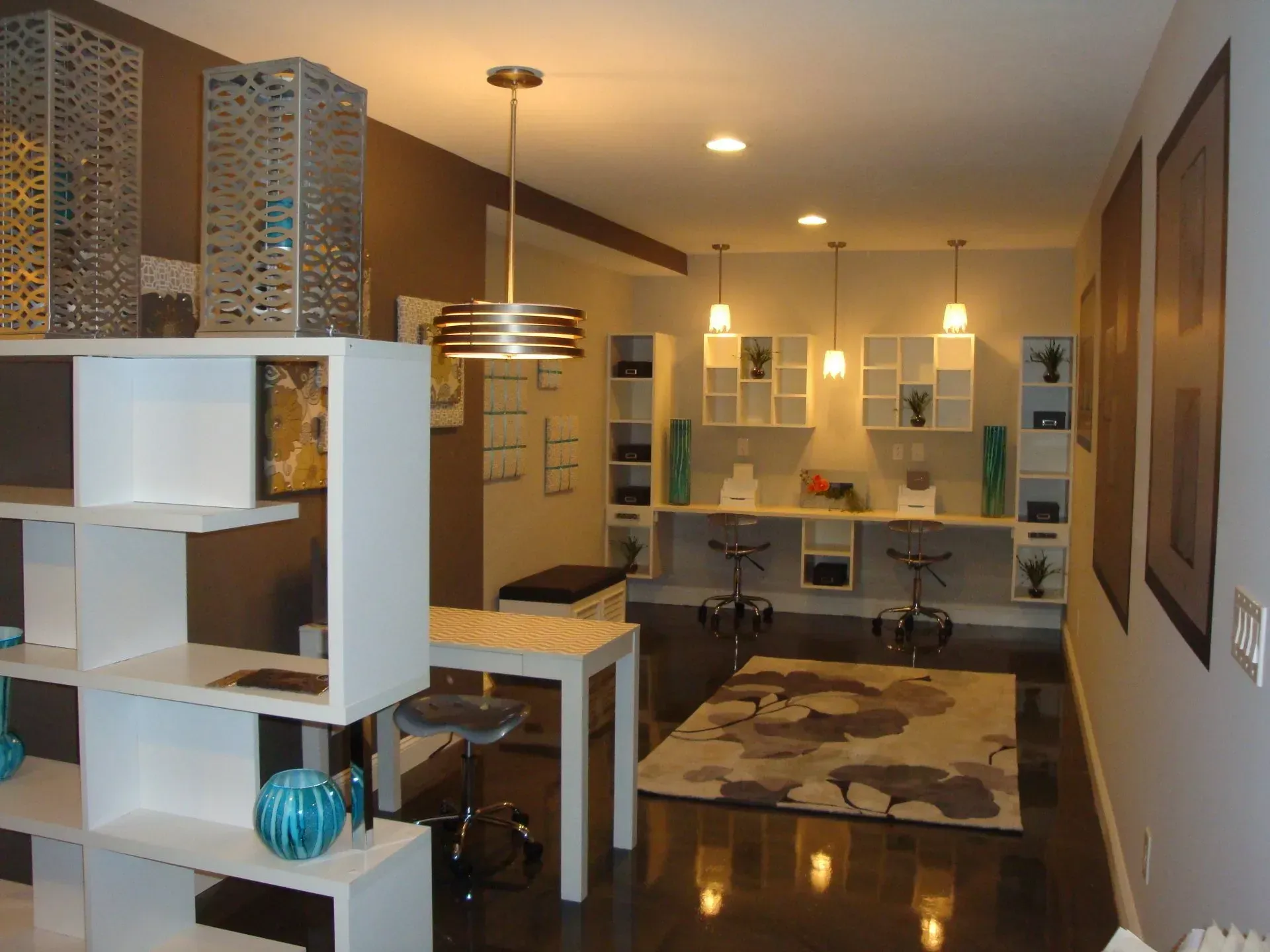Interior of a modern salon with white and brown decor, including shelves and work stations.