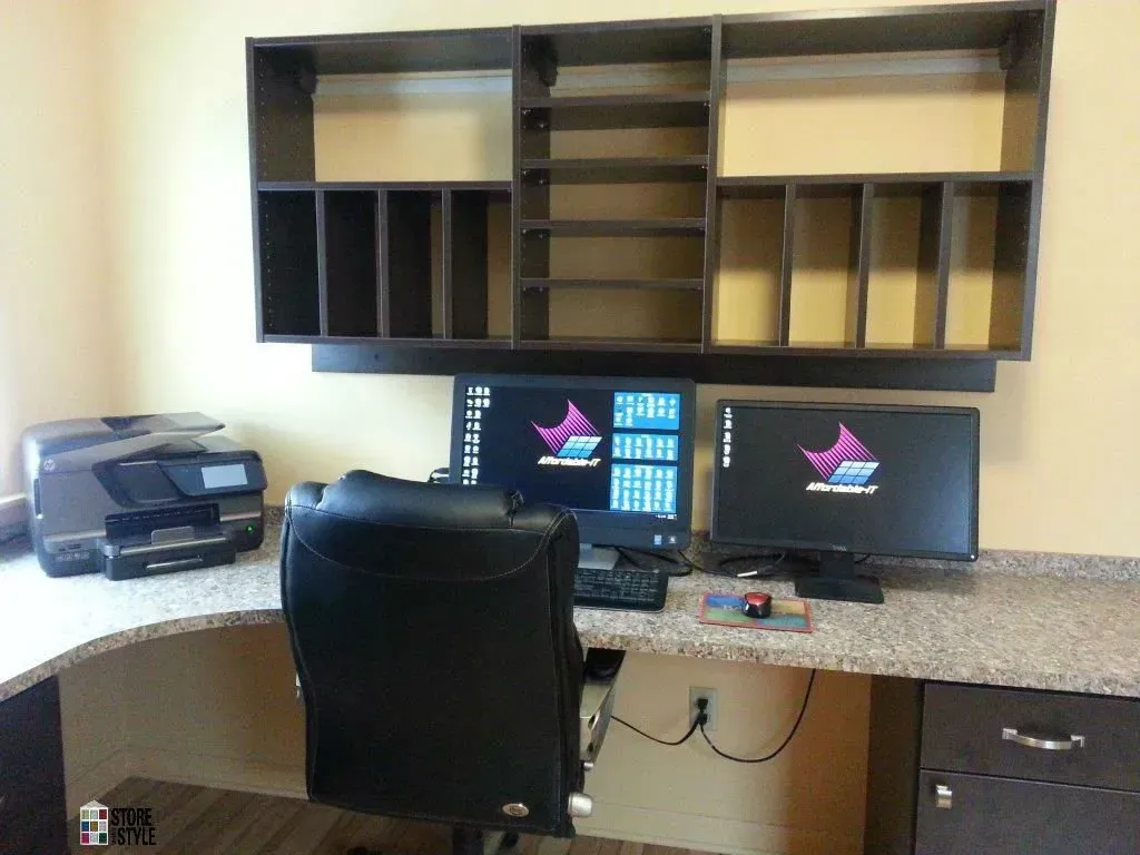 Home office setup with a computer, printer, desk, and overhead storage.