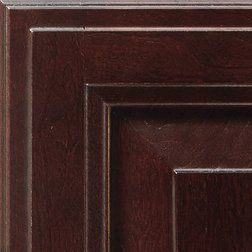 Close-up of a corner of a dark cherry-stained wood cabinet door with recessed panels.
