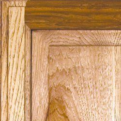Close-up of wood cabinet door and frame in shades of brown and tan, showing grain detail.